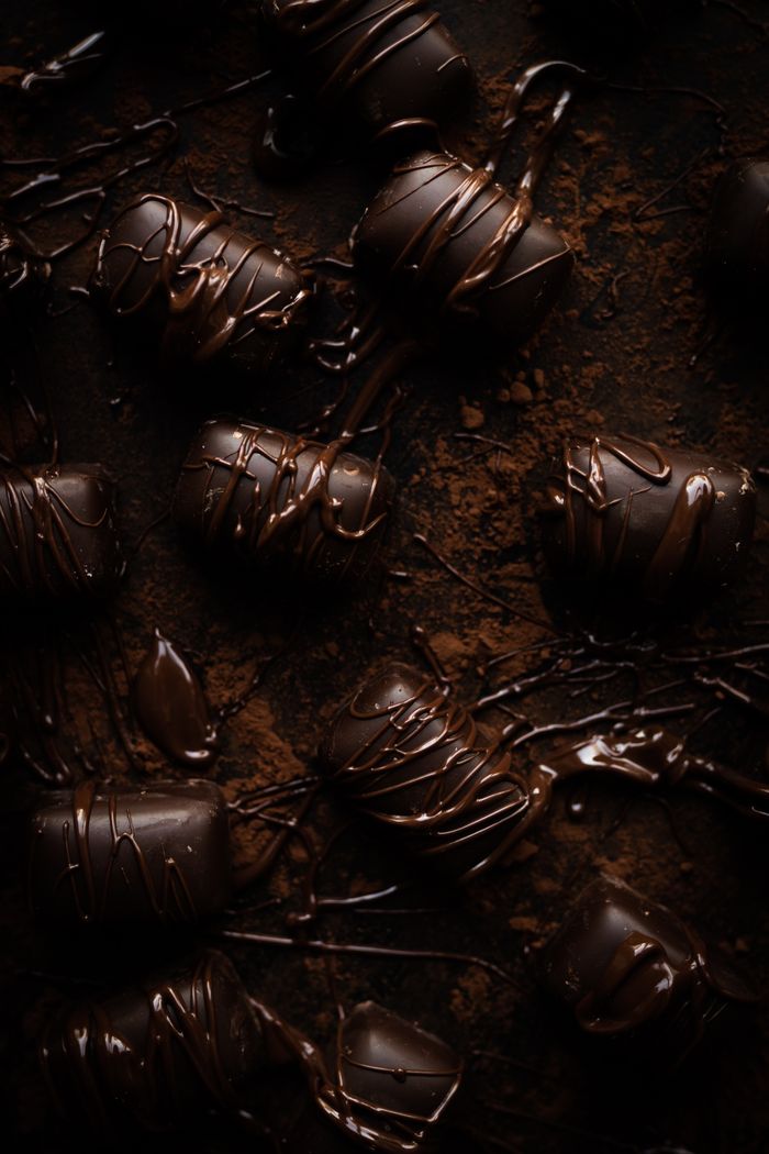 Home Delectable dark chocolate bonbons artfully drizzled and arranged in an enticing manner.