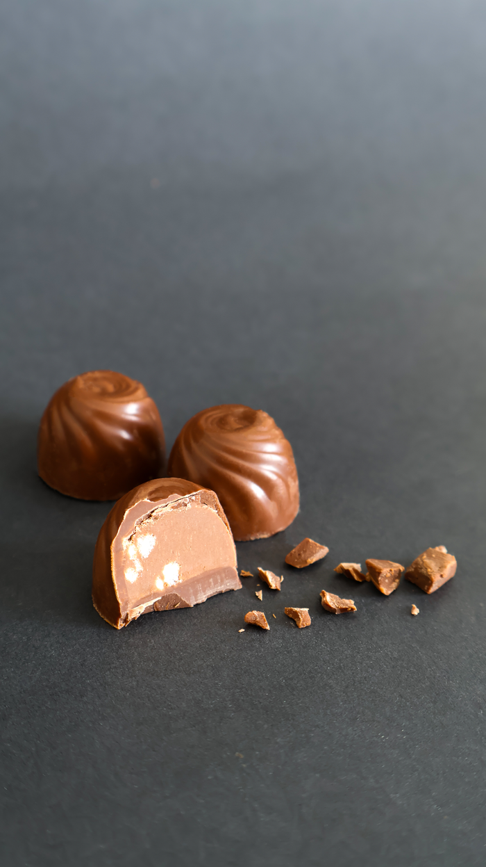 Home Milk chocolate truffles on a dark surface, highlighting creamy textures and rich flavor.