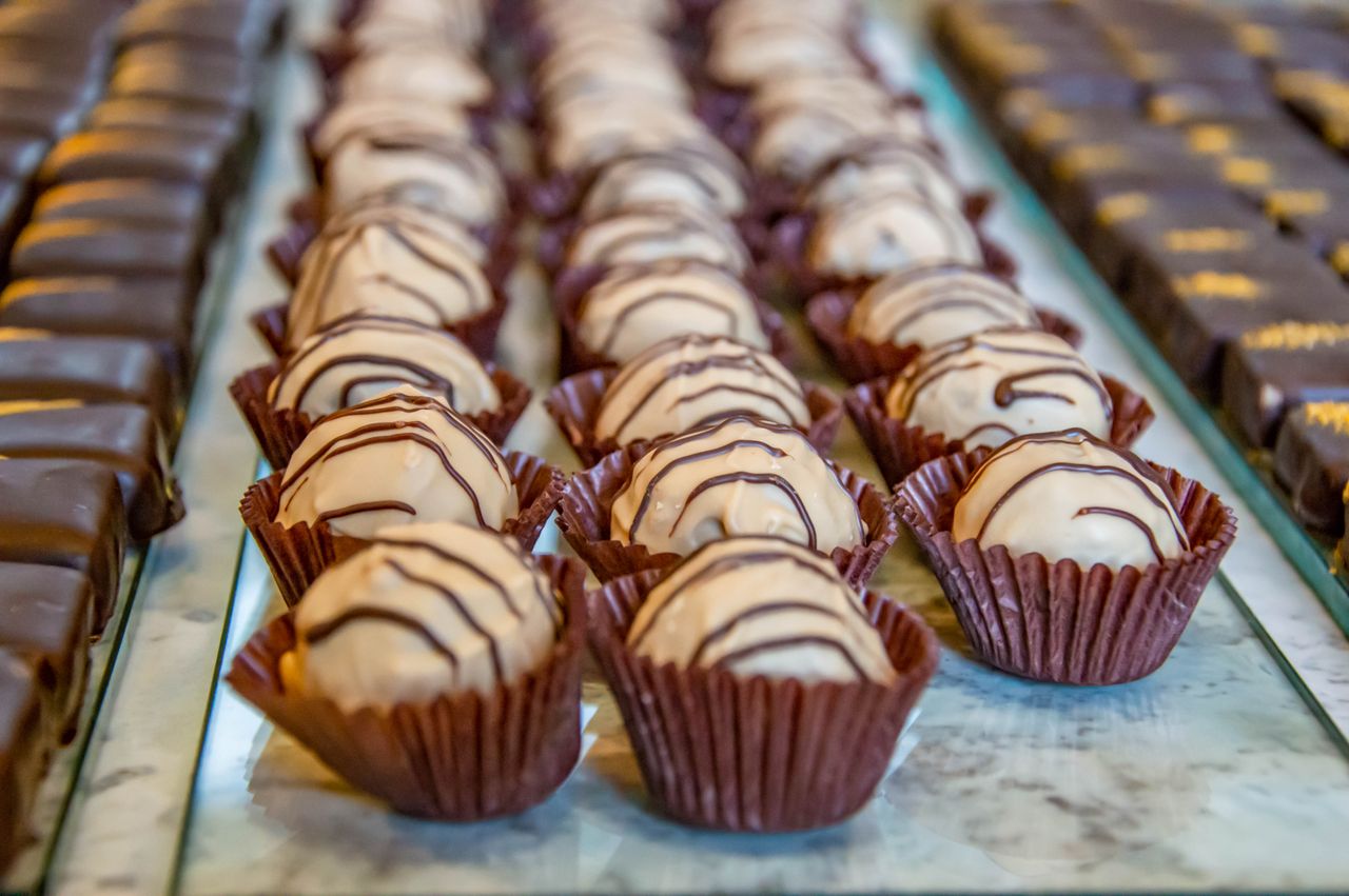 menu-01 Delicious gourmet chocolate truffles displayed in rows, perfect for dessert lovers and bakery settings.